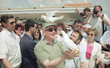 A peace dove sits on the head of former Soviet President Mikhail Gorbachev on Monday, June 15, 1992 as he sets another bird free during a leisure trip on the Sea of Gallilee, Israel. (AP Photo/Jerome Delay)