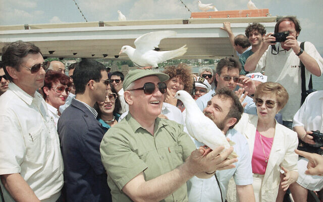 A peace dove sits on the head of former Soviet President Mikhail Gorbachev on Monday, June 15, 1992 as he sets another bird free during a leisure trip on the Sea of Gallilee, Israel. (AP Photo/Jerome Delay)