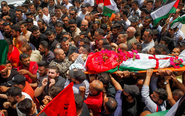 File: Mourners carry the body of Ali Harb, who was allegedly stabbed to death by an Israeli settler, during his funeral in the northern West Bank village of Iskaka on June 22, 2022. (Nasser Ishtayeh/Flash90)