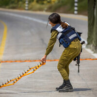 An Israeli soldier places spikes on a road near the border with the Gaza Strip on August 4, 2022. (Flash90)