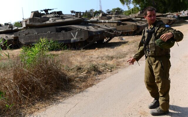 Soldier seen near IDF tanks stationed near the Gaza border on August 5, 2022 (Tomer Neuberg/Flash90)