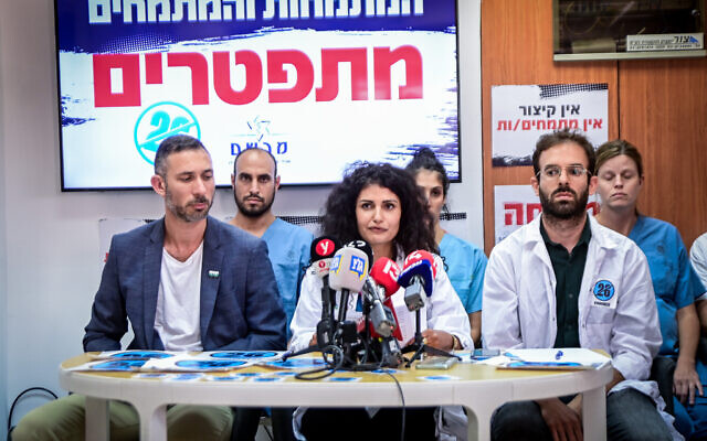 Dr. Rey Biton (center), head of the Mirsham organization of medical residents, holds a press conference alongside other residents in Tel Aviv on August 25, 2022. (Avshalom Sassoni/Flash90)