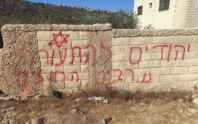 A slogan reading 'Jews wake up. Arabs out' is grafittied on a wall in the West Bank town of Marda, August 24, 2022. (Courtesy)