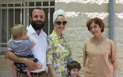 From left to right: baby Yosef Zalman, Israel, Lea, Nathan, and Israel's mother Haya-Rina in the backyard of their Neve Daniel home. (Jeremy Sharon)