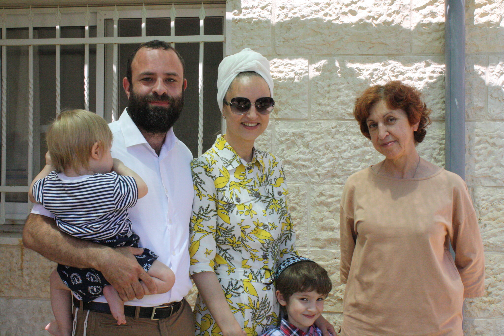 The Libenson family (from left): baby Yosef Zalman, Israel, Lea, Nathan, and Israel's mother Haya-Rina in the backyard of their new home in the settlement of Neve Daniel, some 15 kilometers south of Jerusalem. (Jeremy Sharon)