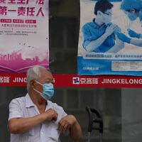 Illustrative: A man near a poster promoting vaccination in Beijing, China, July 19, 2022. (AP Photo/Ng Han Guan)