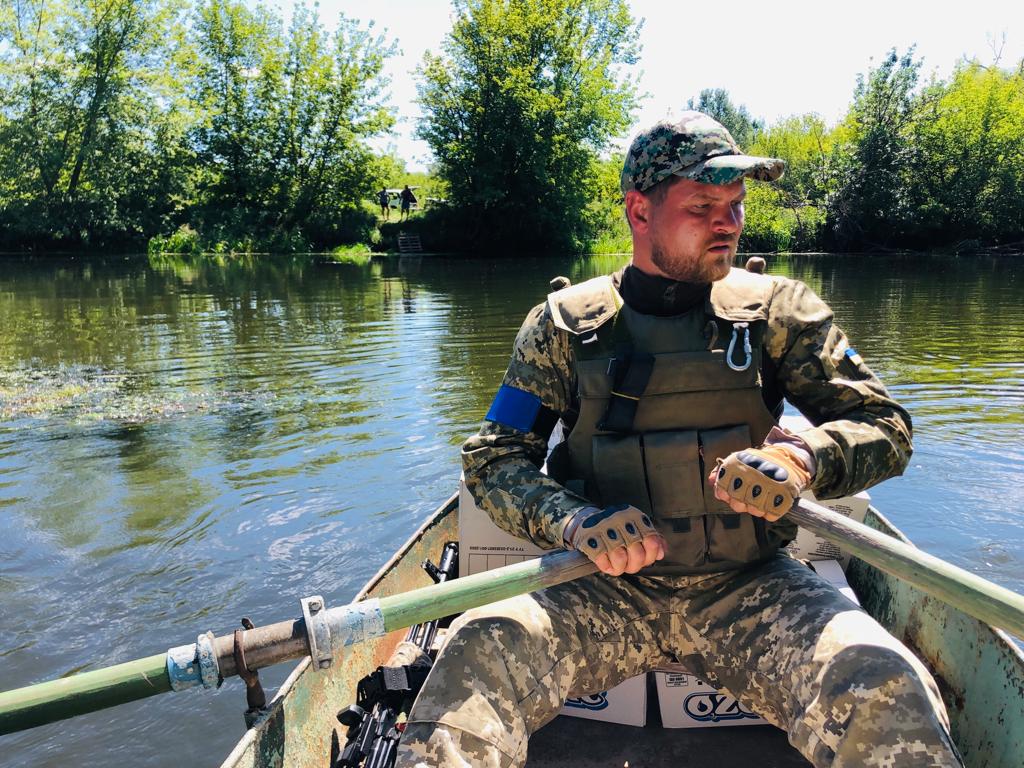 A Ukrainian soldier ferries supplies across the Siverskyi Donets River near Zadonets'ke, July 29, 2022 (Lazar Berman/The Times of Israel)