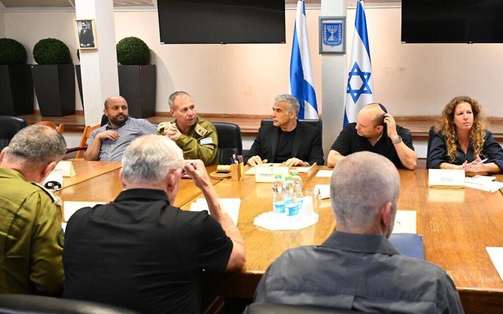 Prime Minister Yair Lapid, center, with other officials at a situational assessment at Defense Ministry HQ in Tel Aviv late on August 7, 2022. (Haim Zach/ GPO)