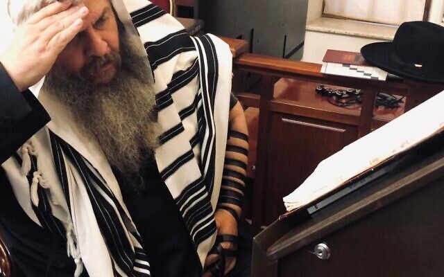 Chief Rabbi of Kyiv's Brodsky Synagogue Rabbi Moshe Azman at prayer, August 8, 2022 (Lazar Berman/The Times of Israel)