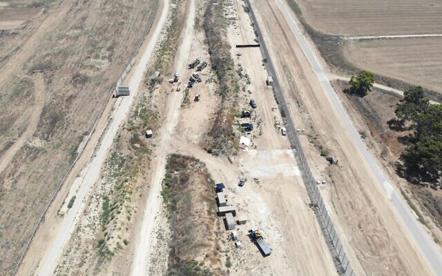An aerial view shows security forces uncovering a Hamas tunnel along the northern Gaza border, in an image published by the IDF on August 15, 2022. The fence on the left is Israel's old barrier along the internationally recognized border, and the right fence is the new one, with the underground barrier. (Israel Defense Forces)
