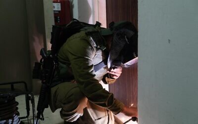 An Israeli soldier welds a door shut, in the West Bank city of Ramallah, August 18, 2022. Israeli troops operated against several Palestinian rights organizations it has declared as terror groups. (Israel Defense Forces)