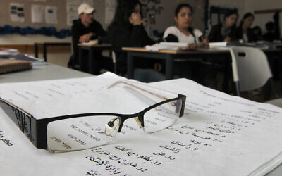 Illustrative: A pair of glasses rests on a worksheet used to teach Arabic to Israeli students. (Nati Shohat/Flash90)