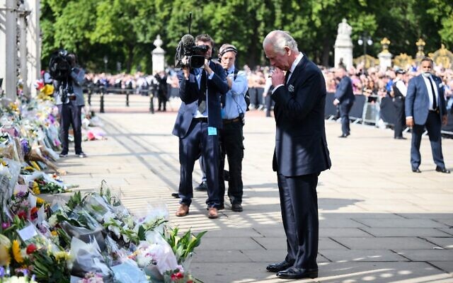 Britain's King Charles III looks at floral tributes left outside of Buckingham Palace in London, on September 9, 2022, a day after Queen Elizabeth II died at the age of 96 (Daniel LEAL / AFP)