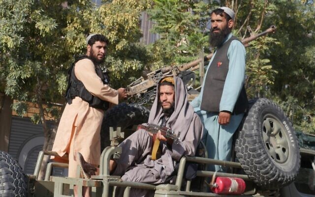Taliban fighters stand on the back of a vehicle as they conduct a 'house to house' inspection in Herat, on September 11, 2022. (Mohsen Karimi / AFP)