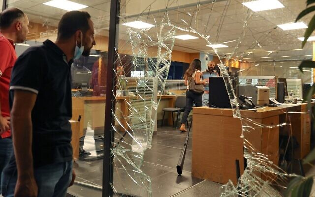 The glass facade of a bank in the Lebanese capital Beirut is broken, after a woman stormed it demanding access to her sister's deposits to allegedly pay for her hospital fees, on September 14, 2022. (Anwar Amro/AFP)