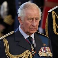 Britain's King Charles III reacts as the coffin of Queen Elizabeth II, adorned with a Royal Standard and the Imperial State Crown and pulled by a Gun Carriage of The King's Troop Royal Horse Artillery, arrives at the Palace of Westminster, following a procession from Buckingham Palace, in London on September 14, 2022. (ALKIS KONSTANTINIDIS / POOL / AFP)