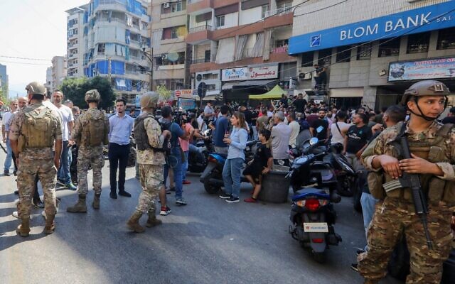 Lebanese security forces are deployed as people gather outside the Blom Bank branch in the capital Beirut's Tariq al-Jdideh neighborhood on September 16, 2022, to express their support to a depositor, who stormed the bank demanding to withdraw his frozen savings. (Ibrahim AMRO/AFP)