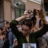 Nasibe Samsaei, an Iranian woman living in Turkey, cuts her ponytail off during a protest outside the Iranian consulate in Istanbul on September 21, 2022, following the death of an Iranian woman after her arrest by the country's morality police in Tehran. (Yasin AKGUL / AFP)