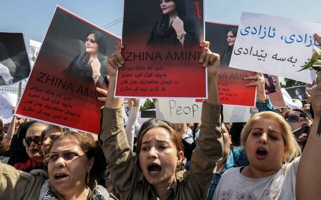 Women chant slogans and hold up signs depicting the image of 22-year-old Mahsa Amini, who died while in the custody of Iranian authorities, during a demonstration denouncing her death held by Iraqi and Iranian Kurds outside the UN offices in Arbil, the capital of Iraq's autonomous Kurdistan region, on September 24, 2022. (Safin Hamed/AFP)