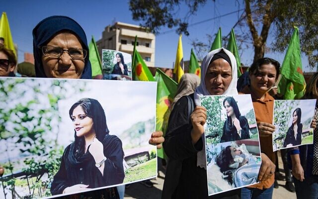 Syrian Kurdish women take part in a demonstration in Syria's northeastern city of Hasakeh on September 25, 2022, to express their support for 22-year-old Mahsa Amini (portrait), who died while in the custody of Iranian authorities. (Delil SOULEIMAN / AFP)
