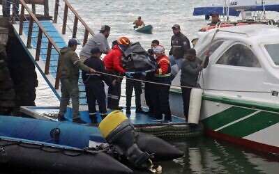 Firefighters and Navy personnel carry a body recovered from the sea in Puerto Ayora in Santa Cruz Island, Galapagos Islands, on September 26, 2022, after a boat with tourists sank in the archipelago located 1,000 km off the coast of Ecuador in the Pacific Ocean. (Carlos Villalba/AFP)