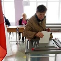 A woman casts her ballot for a referendum on joining the Russian Federation at a polling station in Mariupol, under the control of the pro-Russian Donetsk People's Republic on September 27, 2022. (STRINGER/AFP)