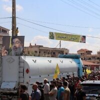 File: People hold portraits of the head of Hezbollah, Hassan Nasrallah, as they gather to welcome tankers carrying Iranian fuel, upon their arrival from Syria in the city of Baalbeck, in Lebanon's Bekaa valley, on September 16, 2021. (AFP)