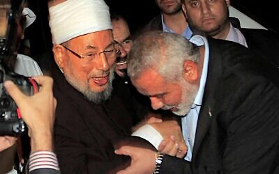 In this file photo, Hamas leader Ismail Haniyeh kisses the hand of Egyptian Cleric and chairman of the International Union of Muslim Scholars Sheikh Yusuf al-Qaradawi upon the latter's arrival at Rafah Crossing in the southern Gaza Strip, May 8, 2013. (Said Khatib/AFP)