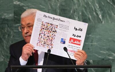Palestinian Authority President Mahmoud Abbas holds up a New York Times front page showing children killed in the May 2021 Israel-Hamas conflict as he addresses the 77th session of the United Nations General Assembly in New York on September 23, 2022 (Michael M. Santiago/Getty Images/AFP)