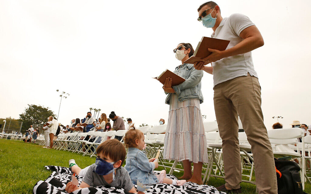 A family prays during an outdoor Yom Kippur service at Sinai Temple during the coronavirus pandemic, undated. (Getty Images via Al Seib/JTA)