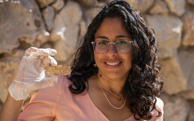 Reli Avisar from Tel Aviv University with a 8th-7th century BCE ivory plaque adorned with a lotus flower from the City of David. (Yaniv Berman, Israel Antiquities Authority)
