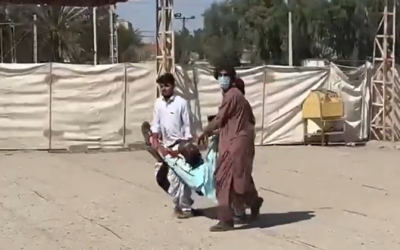 Two men carry an injured man following an exchange of gunfire at a police station in Zahedan, the capital of Sistan and Baluchestan Province in Iran, September 30, 2022. (Twitter screenshot, used in accordance with Clause 27a of the Copyright Law)
