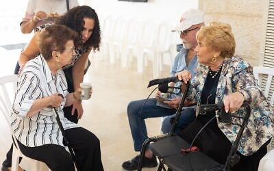 Holocaust survivors chat at the Yad Vashem Holocaust Remembrance Center during an event in which they were thanked for speaking to groups about their experiences, on September 19, 2022. (Yad Vashem)