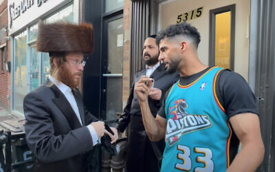 Abdulla Almasmari, otherwise known as YouTuber Dulla Mulla, left, interviewing Orthodox men in Brooklyn about the Israeli-Palestinian conflict, in a video deemed antisemitic. (Screen capture: YouTube)