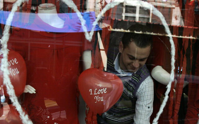 A Palestinian vendor is seen inside his shop decorated for Valentine's Day, in the West Bank city of Nablus, Feb. 14, 2011. (AP Photo/Nasser Ishtayeh)