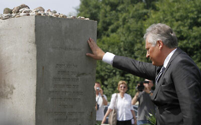 File - Former Polish President Alekdander Kwasniewski touches the statue  after praying for the dead at a ceremony marking 70 years since Poland's villagers murdered hundreds of their Jewish neighbors during World War II in Jedwabne, Poland, July 10, 2011. (AP Photo/Czarek Sokolowski)