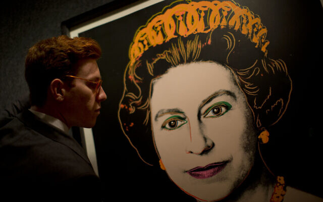 Bonhams employee George Foren poses for photographs with a rare trial proof copy of Andy Warhol's 1985 portrait of Britain's Queen Elizabeth II, at the auction house's offices in central London, Monday, July 9, 2012.    (AP Photo/Matt Dunham)