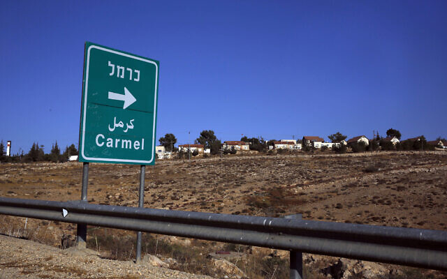 This photo from October 28, 2016, shows a road sign indicating the direction to the Israeli settlement of Carmel, southeast of the West Bank city of Hebron. (AP Photo/Nasser Shiyoukhi)