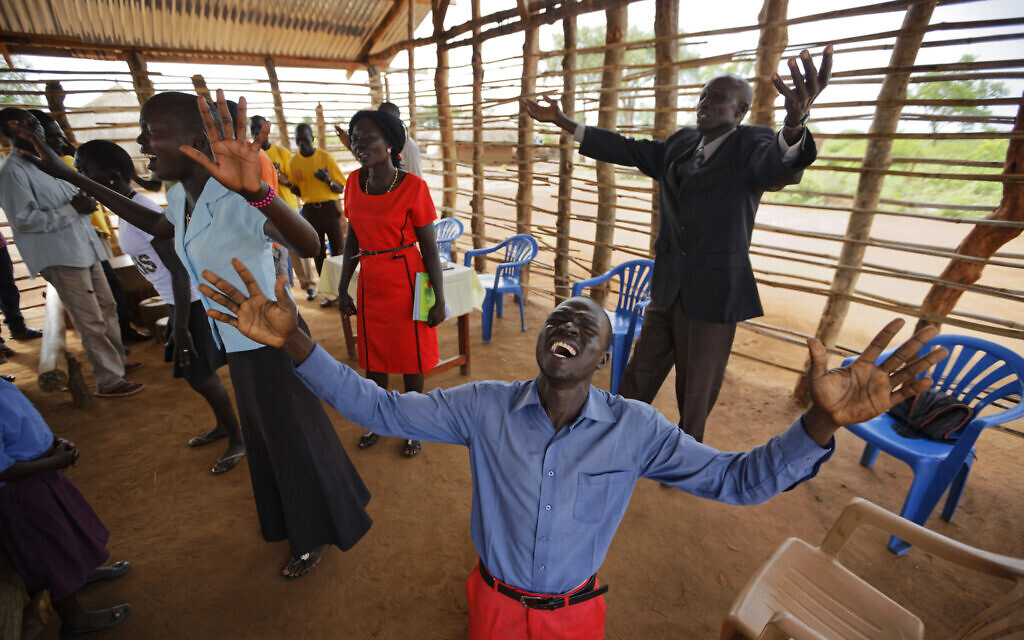In this June 4, 2017, file photo, preacher Daniel Rasash falls to his knees and weeps in prayer, at the Yoyo Pentecostal Church in Bidi Bidi South Sudanese refugee settlement in northern Uganda. (AP Photo/Ben Curtis, File)