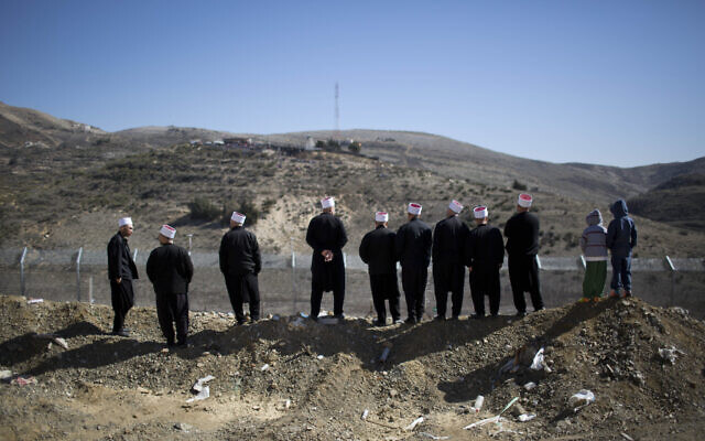 Druze men look out over the border between Israel and Syria near Majdal Shams in the Golan Heights on February 14, 2014. (AP/Oded Balilty)