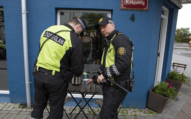 Illustrative: Two police officers help themselves to free coffee after standing guard outside the inauguration of Iceland's president Guðni Th. Jóhannesson in Reykjavik, Iceland Saturday August 1, 2020. (AP/Árni Torfason)