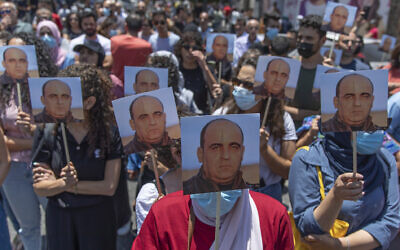 Angry demonstrators carry pictures of Nizar Banat, an outspoken critic of the Palestinian Authority, and chant anti-PA slogans during a rally protesting his death, allegedly at the hands of PA security personnel, in the West Bank city of Ramallah, June 24, 2021. (AP/Nasser Nasser)