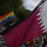 File: Demonstrators, some carrying the rianbow flag, pass the flag of Qatar and the flags of other countries where homosexuality is included in the penal code during a Pride Walk in Amsterdam, Netherlands, Saturday, July 30, 2022, calling for equal rights for members of the LGBT community (AP Photo/Peter Dejong)