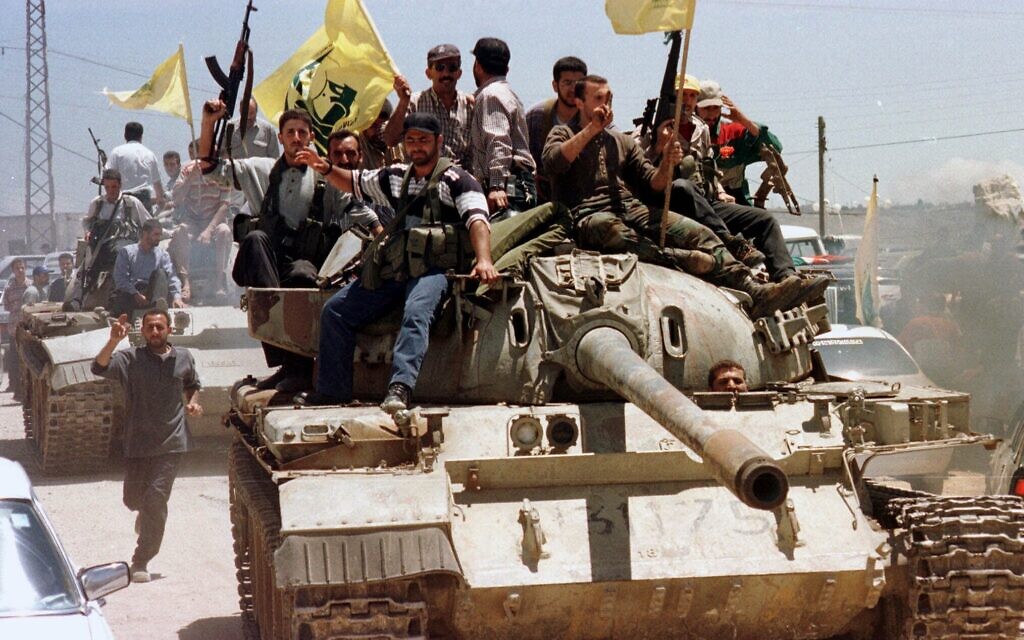 Waving their flags, Hezbollah fighters sit on a top of an Israeli allied South Lebanon Army tank while touring in the streets near the village of Kfar Kila, May 24, 2000. (AP Photo/Mohamed Zatari, File)