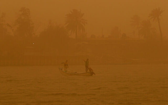 Fishermen navigate on the Shatt al-Arab waterway during a sandstorm in Basra, Iraq, May 23, 2022. The eastern Mediterranean and Middle East are warming almost twice as fast as the global average, with temperatures projected to rise up to 5 degrees Celsius (9 degrees Fahrenheit) by the end of the century if no action is taken to reverse the trend, a new report says. (AP Photo/Nabil al-Jurani, File)