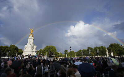 People gather outside Buckingham Palace in London as a double rainbow appears in the sky, Thursday, Sept. 8, 2022. (AP Photo/Frank Augstein)