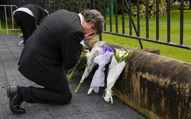 A man reacts after laying flowers outside Government House following the passing of Queen Elizabeth II in Sydney, Australia, September 9, 2022. (AP Photo/Mark Baker)