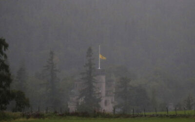 A flag flaps in the wind at half staff over Balmoral Castle in Aberdeenshire, Scotland, Friday, Sept. 9, 2022. Queen Elizabeth II, Britain's longest-reigning monarch and a rock of stability across much of a turbulent century, died Thursday after 70 years on the throne. She was 96. (AP Photo/Scott Heppell)