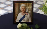 A white rose placed by French President Emmanuel Macron near a portrait of Queen Elizabeth, following the passing of Britain's Queen Elizabeth, is seen at the British Embassy in Paris, France, September 9, 2022. Christian Hartmann/Pool via AP)