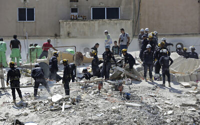 Jordanian Civil Defense rescue teams conduct a search operation for residents of a four-story residential building that collapsed on Tuesday, killing several people and wounding others, in the Jordanian capital of Amman, September 14, 2022. (AP Photo/Raad Adayleh)